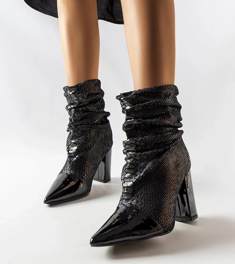 Schwarze gerunzelte Stiefeletten auf dem Pfosten von Liang