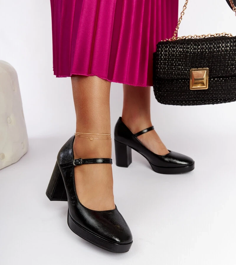 Schwarze lackierte Pumps auf Säule von Cher