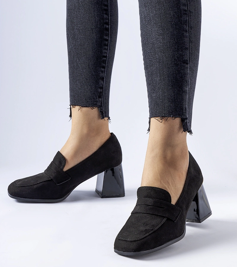 Schwarze Lackpumps auf einem Pfosten von Mill